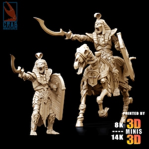 Puede incluir: Dos figuras en miniatura beige de antiguos guerreros egipcios. Una figura está a pie, sosteniendo una espada curva y un escudo. La otra figura está montada en un caballo esquelético, también empuñando una espada curva. Las figuras están detalladas con diseños jeroglíficos e impresas en 3D.