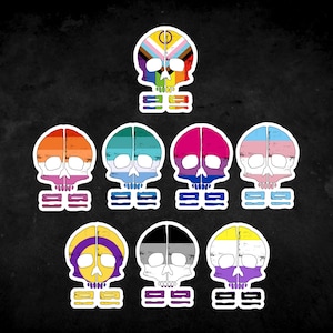 Pode incluir: Nove adesivos de caveira com diferentes bandeiras do orgulho. As bandeiras incluem as bandeiras do arco-íris, transgênero, bissexual, pansexual, genderqueer, lésbica e assexual. Cada adesivo tem o texto "999" abaixo da caveira.