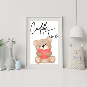 May include: A white framed print with a brown teddy bear holding a red heart. The text "Cuddle Time" is written in black cursive.