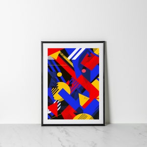 Op de afbeelding: Abstracte geometrische kunstprint in een zwart frame. De print heeft een kleurrijk ontwerp met rode, gele, blauwe en zwarte vormen.