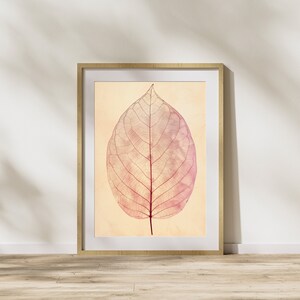May include: A framed print of a single, delicate, pink leaf with visible veins against a light beige background.