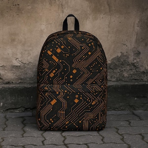 Puede incluir: Una mochila negra con un patrón de placa de circuito naranja. La mochila tiene un compartimento principal con cremallera y un bolsillo frontal más pequeño.