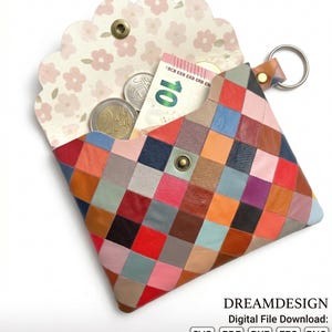 May include: A small envelope-style pouch featuring a multicolored patchwork design of square leather pieces in red, blue, orange, pink, and brown. The interior flap has a light cream background with a pink floral pattern and a metal snap closure.
