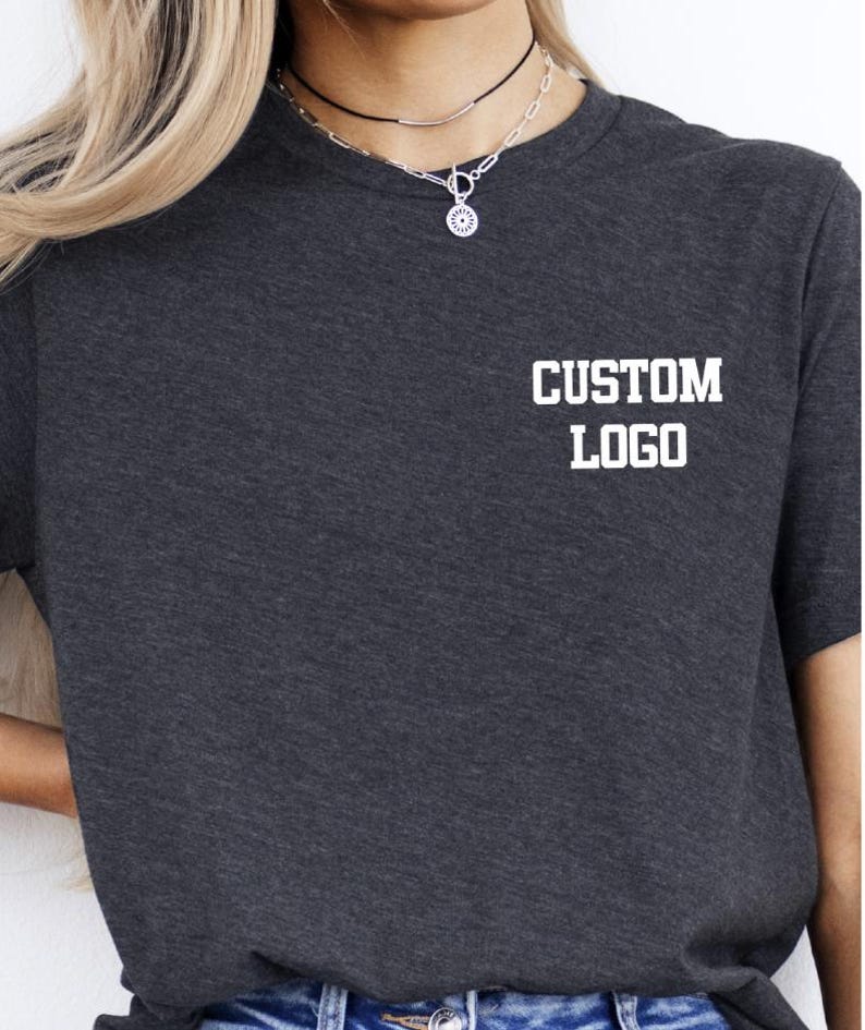 May include: Dark gray t-shirt with the text "CUSTOM LOGO" printed in white on the upper chest. The shirt is a basic crew neck style and appears to be made of a soft material.