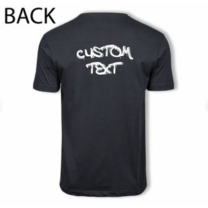Pu&ograve; includere: Maglietta nera con testo bianco che dice "CUSTOM TEXT" in stile graffiti.