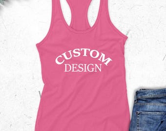 May include: A pink racerback tank top with the words "CUSTOM DESIGN" in white, arched across the front. The tank top is displayed with a pair of blue jeans.