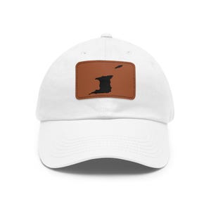 May include: A white baseball cap featuring a rectangular brown patch centered on the front. The patch displays a black silhouette of the islands of Trinidad and Tobago, with the larger island on the left and the smaller island positioned to the right.