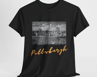 May include: Black t-shirt with a black and white photo of the Pittsburgh skyline and the word "Pittsburgh" in orange and yellow lettering.