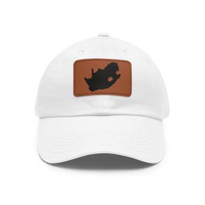 Peut inclure: Une casquette de baseball blanche avec un écusson rectangulaire marron centré sur le devant. L'écusson présente une silhouette noire unie de la carte de l'Afrique du Sud. La casquette possède une visière courbée et une calotte structurée.