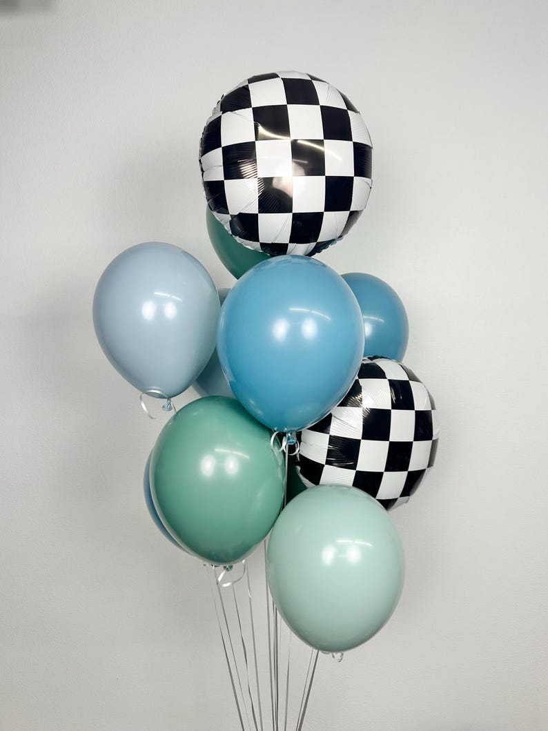 Puede incluir: Un conjunto de globos en varios tonos de azul, verde y blanco. Dos globos tienen un patr&oacute;n de cuadros blancos y negros. Los otros globos son de colores lisos. Los globos est&aacute;n atados con cintas transparentes.