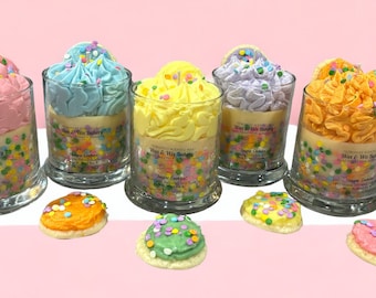 May include: Six glass jars with colorful frosting and sprinkles, resembling cupcakes, labeled "Sugar Cookies" and "Her & His Bakery".  Each jar is accompanied by a matching cookie with frosting and sprinkles.