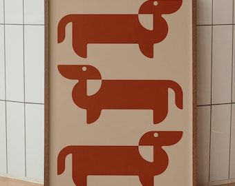 May include: A rectangular framed wall art print featuring three stylized dachshund dogs in a solid burnt orange color. The dogs are arranged in a vertical column against a light beige background, each depicted with geometric shapes and a small white eye.
