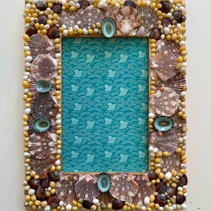Marco de fotos artesanal con diseño de conchas marinas