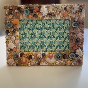 Marco de fotos artesanal con diseño de conchas marinas