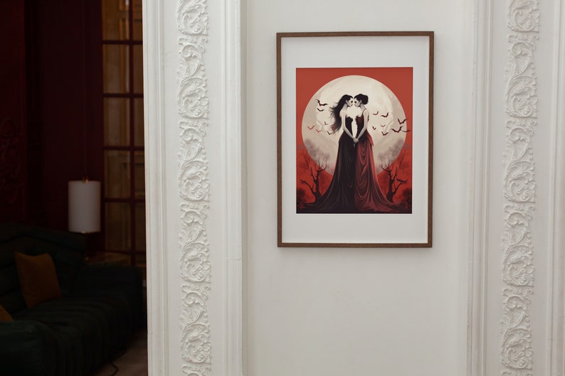 May include: A framed illustration of two women in red dresses standing together under a full moon. The background is a red and orange sky with bats flying around the moon.