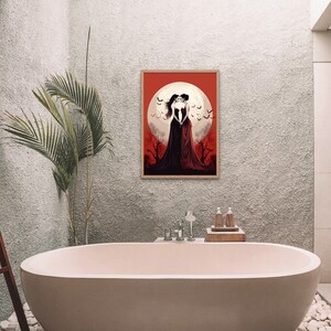 May include: A framed illustration of two women in long black dresses standing in front of a full moon with bats flying around them. The background is a red and orange gradient.