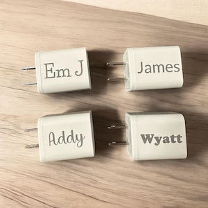 May include: Four white wall plug adapters with different names printed on them: Em J, James, Addy, and Wyatt.