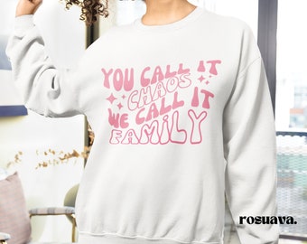 May include: White sweatshirt with pink text that reads "You call it chaos we call it family".