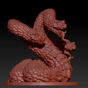 Può includere: Una scultura di un serpente a tre teste con una superficie testurizzata e squamosa. La scultura è realizzata in un materiale marrone rossiccio ed è in posizione arrotolata.