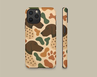 May include: A smartphone case featuring a repeating pattern of brown dog heads, dark green and tan abstract shapes, and paw prints on a light beige background. The design covers the back and side of the case, showing the camera lens cutout area.