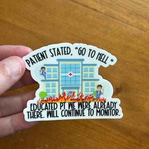 May include: A white sticker with the text "PATIENT STATED, 'GO TO HELL'" above a cartoon hospital on fire. The text "EDUCATED PT WE WERE ALREADY THERE. WILL CONTINUE TO MONITOR." is below the hospital.