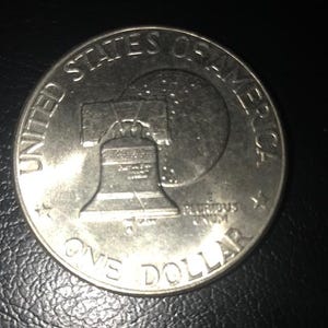 Könnte beinhalten: Eine silberne US-amerikanische Ein-Dollar-Münze mit der Liberty Bell und der Aufschrift "United States of America" und "One Dollar".