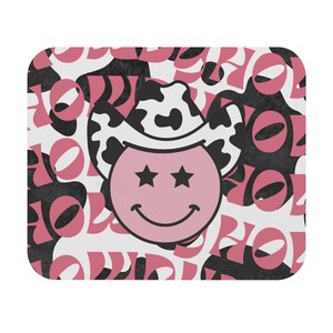 May include: Pink and black smiley face with a cowboy hat on a white background with a repeating pattern of the word "HOLIDAY" in pink and black.