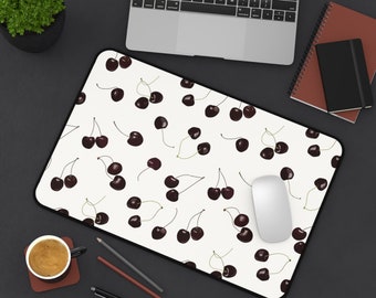 Può includere: Un tappetino per mouse bianco con un bordo nero presenta un motivo ripetitivo di ciliegie rosso scuro su uno sfondo bianco. Un mouse per computer bianco è sul tappetino per mouse.