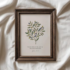 Könnte beinhalten: Ein rechteckiger Wandkunstdruck in einem dunkelbraunen Holzrahmen mit einer Aquarellillustration eines Olivenzweigs mit grünen Blättern und dunkelblauen Oliven. Unter der Illustration steht der Text: He who abides in Me, and I in him, bears much fruit. John 15:5.