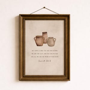 May include: A rectangular antique gold frame containing a print with three watercolour-style clay pots and the text: But now, O Lord, you are our Father; we are the clay, and you our potter; and all we are the work of your hand. Isaiah 64:8.