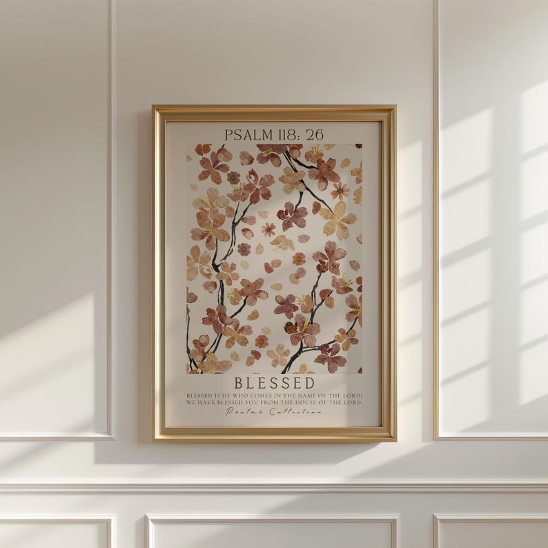 以下が含まれることがあります： 茶色とベージュの色合いの水彩画の花柄が描かれた額装されたプリント。プリントには「PSALM 118: 26」と「BLESSED」の文字と聖書の引用が書かれている。