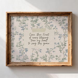 May include: A framed print with a wooden frame. The print features a floral pattern in blue and green, with the words "Come, thou Fount of every blessing, tune my heart to sing thy grace."