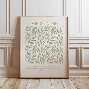 May include: A printable wall art design with a white background and a green leafy pattern. The text "ABIDE IN ME" is at the top of the design. The text "If you abide in Me, and My words abide in you, you will ask what you desire, and it shall be done for you. John 15:7" is at the bottom of the design.