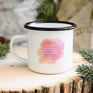 May include: White enamel mug with a black rim. The mug features a pink watercolour design with gold glitter and the text "No harm will overtake you, no disaster will come near your tent. PSALMS 91:10"