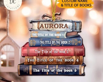 Puede incluir: Una pila de cinco libros con un nombre personalizado "AURORA" en el libro superior. Los libros están decorados con un diseño de estilo vintage y tienen títulos como "El título del libro 1" y "El título del libro 2".