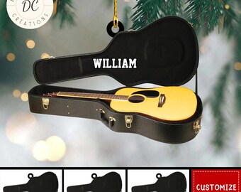 Może przedstawiać: Ozdoba w kształcie gitary akustycznej w czarnym futerale, z białym napisem "WILLIAM". Gitara ma żółty korpus i brązowe akcenty. Ozdoba jest zawieszona na złotym sznurku. Dodatkowe ozdoby gitarowe w różnych kolorach są pokazane poniżej.