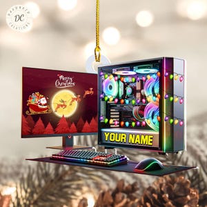 May include: A Christmas ornament featuring a computer setup with a monitor displaying a festive holiday scene, a keyboard, a mouse, and a tower with colorful lights. The tower has a personalized nameplate that says "YOUR NAME".