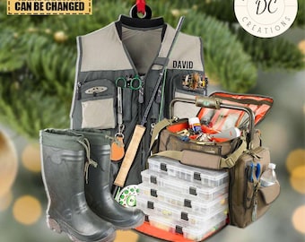 May include: A green and brown fishing vest with a fishing rod, tackle box, and boots. The vest has the name "DAVID" on it. The tackle box is open and has several compartments. The boots are green and have a brown trim. The ornament is decorated with the text "DAS UNKID DC CREATIONS".