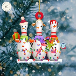 May include: Three snowman-shaped bowling pins decorated with Christmas lights and ornaments. The snowman in the middle is wearing a purple scarf and a red and white candy cane. The snowman on the left is holding a wrapped gift. The snowman on the right is holding a blue gift box.