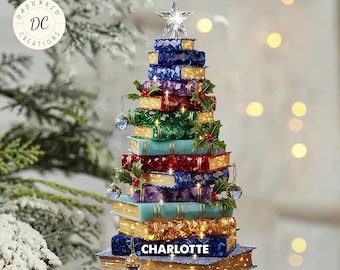 May include: A Christmas tree ornament shaped like a stack of books, with a star on top. The books are various colors, including blue, green, and red, and are decorated with holly and lights. The name "CHARLOTTE" is displayed on the bottom book.
