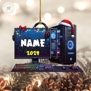 May include: A Christmas bauble featuring a computer monitor, keyboard and mouse, all decorated with Christmas lights. The monitor displays the text "NAME 2024".
