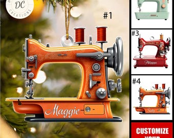 May include: An orange sewing machine ornament with the name "Maggie" on it. The ornament has two spools of thread and a silver-colored wheel. The image also shows three other sewing machine ornaments in different colors.