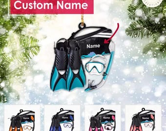 May include: A personalized Christmas ornament featuring a scuba diving set with a mask, snorkel, and flippers. The ornament is blue, black, and white with the text "Name" on the bag.