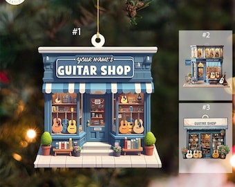 Może przedstawiać: Niebieska i biała ozdoba choinkowa w kształcie sklepu z gitarami z napisem "Your Name's Guitar Shop" nad witryną. Sklep ma pasiasty daszek, okna z wystawionymi gitarami i znak z napisem "Guitar Shop".