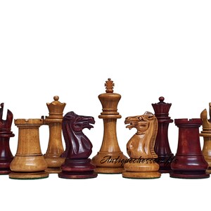 Könnte beinhalten: Ein Satz hölzerner Schachfiguren im klassischen Staunton-Design. Die Figuren sind aus dunkelrotem und hellbraunem Holz gefertigt. König, Dame, Turm, Läufer, Springer und Bauer sind alle sichtbar. Die Figuren sind in einer Reihe auf weißem Hintergrund angeordnet.