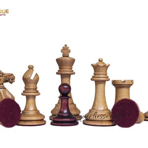 Op de afbeelding: Een set houten schaakstukken, waaronder een paard, een loper, een koning, een dame, een toren en een pion. De stukken zijn lichtbruin met een donkerrode basis. Het logo "Antique Chess Crafts" staat linksboven.