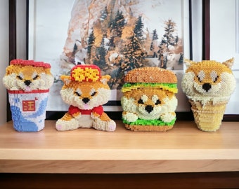 May include: Four adorable Shiba Inu dog figurines made of colourful plastic beads. The figurines are dressed as a cup of ice cream, a hamburger, a takeaway container, and a traditional Chinese outfit.