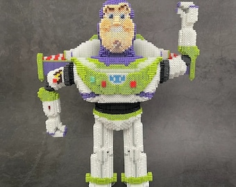 May include: A purple, green, and white toy figure of Buzz Lightyear from the Toy Story franchise. The figure is made of plastic beads and is posed with one arm raised.