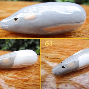 May include: Three ceramic mouse figurines, each with a different color pattern. The first mouse is gray with a light pink belly, the second mouse is gray and white, and the third mouse is gray and white with a light pink belly.