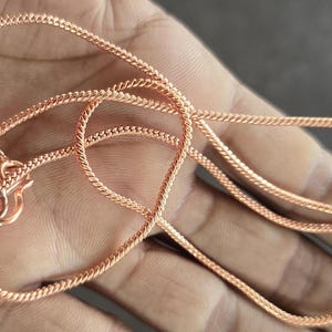 Puede incluir: Un collar de cadena de oro rosa con cierre de mosquet&oacute;n. La cadena est&aacute; hecha de un dise&ntilde;o de cuerda trenzada.